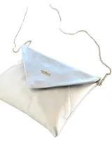 Cartera de mano tipo sobre plateada, de cuero sintético con acabado metalizado. Incluye asa de cadena metálica extraíble y cierre de solapa con imán.