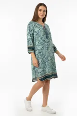 Vestido corto de poliéster con estampado de cachemir en tonos celeste y azul, con mangas 3/4 y cuello redondo con detalle de borlas.