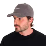 Gorra de pana color mostaza con visera curva, seis paneles y logo de Caterpillar bordado en negro en el frente.