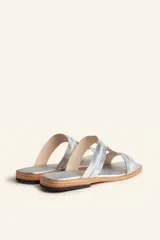 Sandalias bajas de cuero color marrón con costuras blancas a la vista.