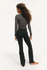 Calzas de yoga acampanadas negras, de tiro alto con cintura ancha con detalle fruncido adelante. Confeccionadas en tejido funcional SoftMove™ con tecnología Lycra® Sport.