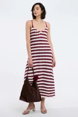 Vestido largo de punto con rayas horizontales blancas y negras, breteles finos y falda acampanada.