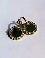 Par de aros colgantes con dije circular de resina con glitter multicolor y borde de strass. El arito es de acero quirúrgico dorado.