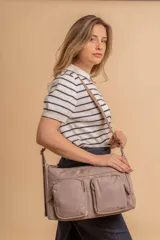 Bandolera de tafeta impermeable, liviana, con dos compartimientos principales, dos bolsillos con cierre y correa regulable con hebilla.