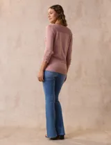 Buzo rosa de tejido combinado, con cuello redondo y mangas 3/4 con detalle de botones.