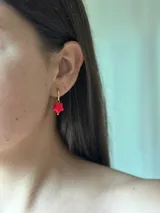 Aros colgantes con forma de estrella roja y aro de acero quirúrgico dorado.