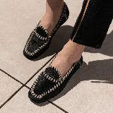 Mocasines negros de cuero vacuno con tientos de cuero pasados a mano y suela de goma.