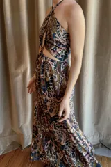 Vestido largo con estampado paisley multicolor, escote halter y aberturas laterales en la cintura con detalles de mostacillas. La espalda es elastizada y la falda es holgada.