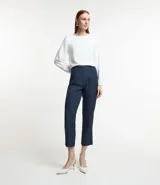 Pantalón zanahoria de sastrería color blanco, con cintura alta, trabillas y botón contrastante.