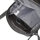 Morral bandolera New Balance color lila con correa negra ajustable, compartimento principal con cierre y bolsillo frontal con cierre.