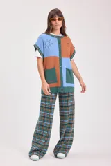 Chaleco de punto con diseño de bloques de color en azul, marrón y verde, con bordados de sol y pájaro.