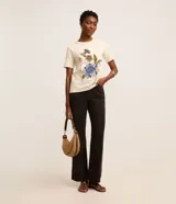 Blusa slim de mangas cortas, confeccionada en algodón, con cuello redondo y estampa floral con lettering caligráfico.