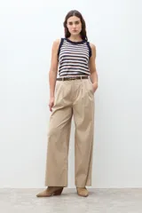Pantalón de mujer color beige, tiro alto, con pliegues (pinzas) frontales y corte ancho y recto en las piernas.