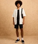Camisa blanca de viscosa con estampado de cocoteros, corte relaxed, cuello inglés, manga corta y cierre abotonado.