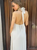 Vestido largo blanco con cuello halter y espalda descubierta.