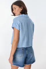 Camisa color beige de lino, con cuello clásico, manga corta con detalle de frunce y bolsillo de parche en el pecho.