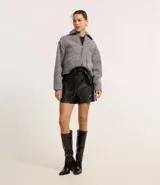 Short negro de cuero sintético con cintura elástica y lazo delantero.