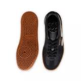Zapatillas de cuero y gamuza en combinación de colores blanco y negro, con suela de goma color marrón.