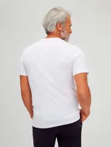 Camiseta básica unisex de color beige, con cuello en V y sin costuras laterales para mayor comodidad.