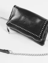 Bandolera negra de cuero vegano con tachas plateadas y correa de cadena metálica.
