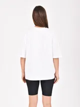 Remera rosa de corte holgado con estampado frontal que dice 'Los Angeles Malibu CA' en azul y naranja.