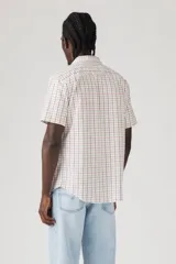 Camisa de manga corta a cuadros color blanco, naranja y azul. Tiene un bolsillo en el pecho con el logo de la marca.