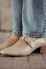 Zapatos de charol color beige con taco bloque de madera y tira sobre el empeine con hebilla dorada.