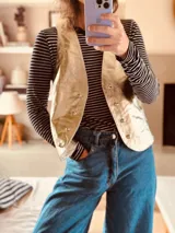 Chaleco de cuero ovino italiano color dorado, con tachas plateadas.