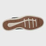 Zapato acordonado de cuero azul marino con suela blanca de goma.