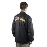 Campera negra tipo windbreaker con cuello camisero, cierre frontal con botones a presión, bolsillos laterales y logo de Thrasher en amarillo en el pecho.