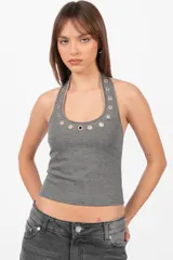 Top gris sin mangas con cuello halter de punto roma. Escote con ojalillos color níquel y vista de algodón con lycra.