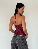 Top halter color bordó con estampado floral, argolla en el cuello y abertura en el frente.