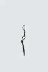 Llavero de cuero negro con detalle de nudo. El cordón presenta una ranura que permite ajustar el llavero como charm colgante en un bolso.