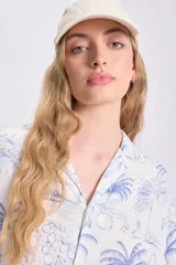 Camisa oversize de manga corta con estampado de palmeras y limones en tonos azules sobre fondo blanco. Confeccionada en lino.