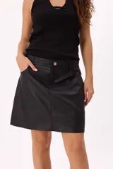 Minifalda negra de cuero sintético, corte evasé y calce cómodo.