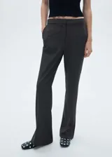 Pantalón de vestir gris oscuro, de corte flare y tiro alto, con bolsillos laterales y traseros de ribete.