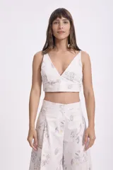 Top crop blanco con estampado de dibujos en tonos grises y marrones, con escote en V y breteles anchos.