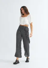Pantalón palazzo de rayas verticales en blanco y negro, con lazo en la cintura y corte amplio.