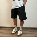 Short negro de algodón con corte holgado y ruedo desflecado.