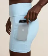 Conjunto deportivo celeste compuesto por un top con breteles anchos y detalle de malla en el escote, y un short de calce ajustado con bolsillos laterales.