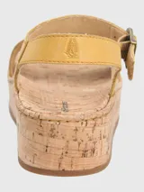 Sandalias amarillas con plataforma de corcho y ajuste con hebilla.