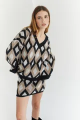 Sweater de lana color beige con diseño geométrico de rombos en tonos beige y blanco, cuello en V y corte holgado.