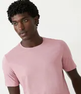 Remera slim de manga corta color salmón, de punto medio, sin estampado y cuello redondo.