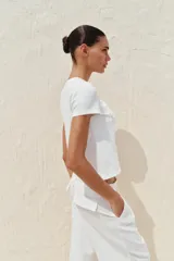 Camiseta blanca de algodón con cuello redondo, manga corta y detalle de corazón con tejido en relieve en el delantero.