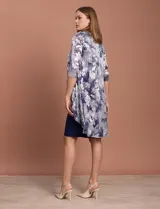 Conjunto de vestido azul marino con chaqueta estampada con motivos florales en tonos plateados y azules.