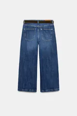 Jeans de tiro alto con pernera ancha y corte cropped. Presenta diseño de cinco bolsillos, cierre frontal con cremallera y botón, e incluye un cinturón a juego.