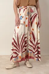 Pollera larga de viscosa color crudo con estampado de hojas azules y detalles en marrón y rojo.