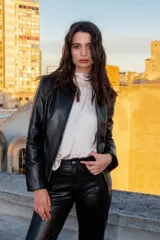 Chaqueta de cuero ovino color negro, con cierre frontal asimétrico y cuello mao.