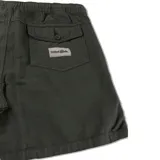 Bermuda de color verde oscuro, estilo cargo o utilitario, con cintura elástica y cordón de ajuste blanco. Presenta paneles verticales cosidos y un pequeño bolsillo cuadrado en el muslo derecho con etiqueta de marca.
