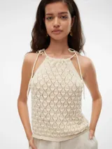 Top de punto color crema, con cuello halter y tiras finas para atar en el cuello.